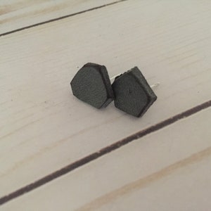 May include: A pair of gray leather stud earrings with a hexagonal shape.