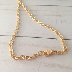 Op de afbeelding: Een gouden ketting met een karabijn sluiting.