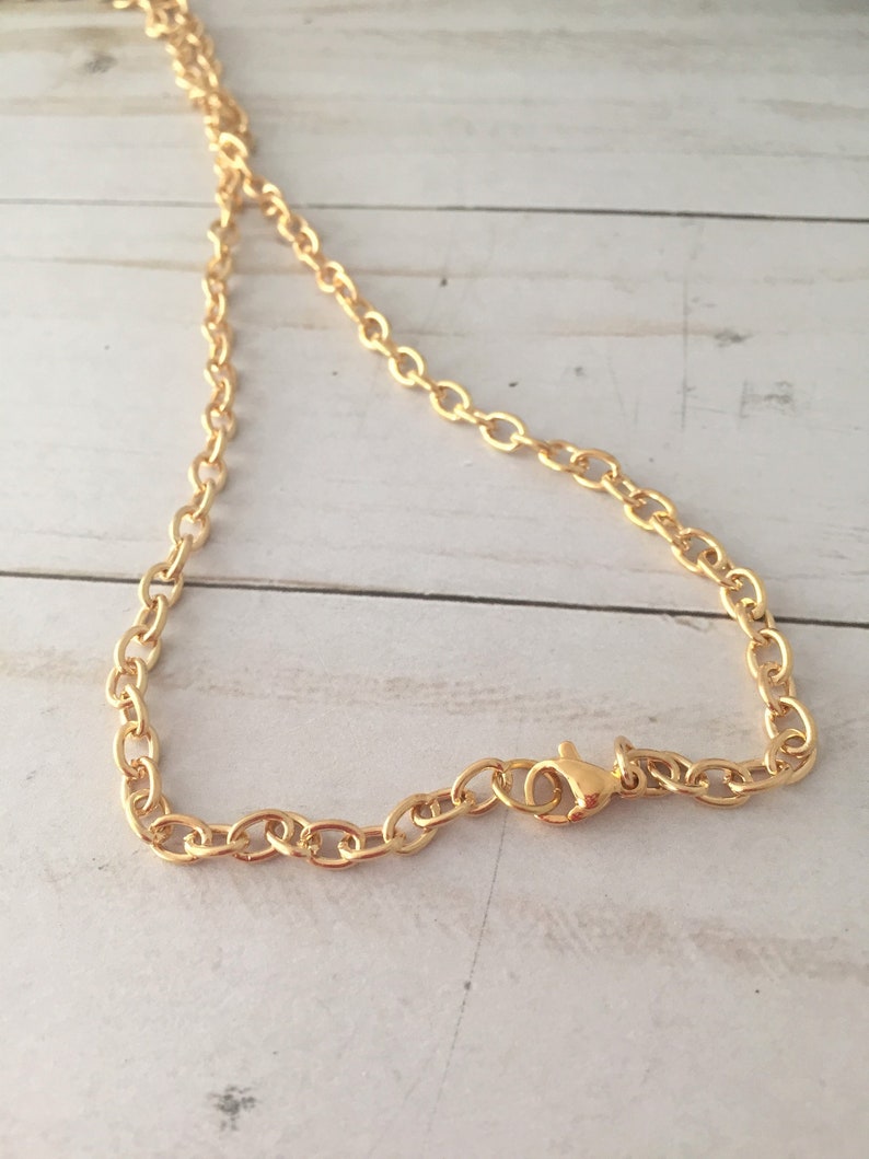 Op de afbeelding: Een gouden ketting met een karabijn sluiting.