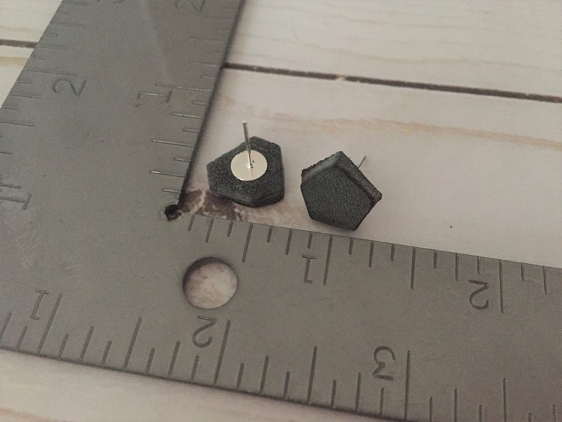 May include: A pair of gray hexagonal stud earrings with silver posts.