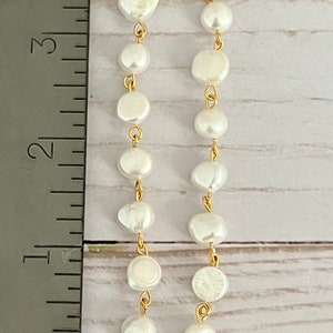 Pu&ograve; includere: Un paio di orecchini d'oro con gocce di perle bianche. Gli orecchini sono lunghi circa 7,6 cm.
