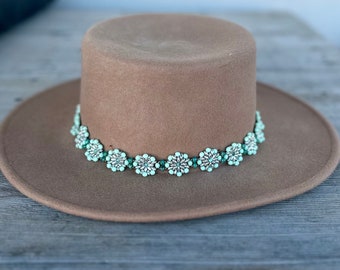 Perlenbesetztes Hutband. Mintgrüne und silberne Perlen sind zu Blumen verflochten und durch dunkelgrüne Rondell Perlen miteinander verbunden.