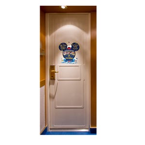 May include: A white door with a decorative sign featuring Mickey Mouse ears. The sign reads "Our First Disney Cruise" and "The [Family Name] Family 2020". Below the ears is a ship and the word "Adventure".