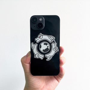 May include: Black phone case with a white graphic of three cats circling a globe. The cats are in a playful pose, with their tails curved. The globe is white with black continents. The phone case has a glossy finish.