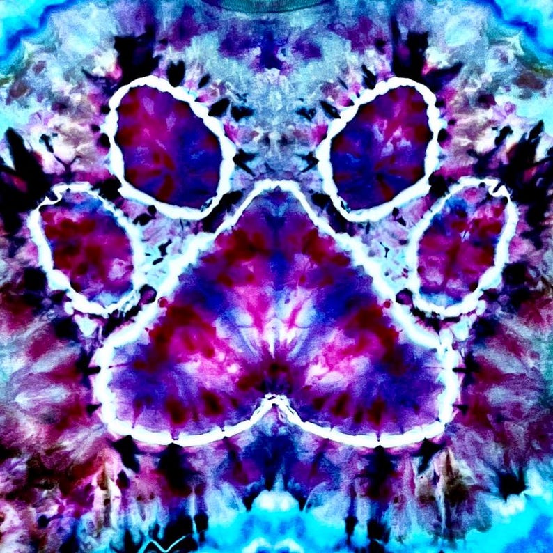 Op de afbeelding: Een tie-dye ontwerp met een grote pootafdruk in paars, roze en blauw. De pootafdruk is wit omlijnd tegen een wervelende achtergrond van vergelijkbare kleuren. Het algehele effect is een levendig, psychedelisch patroon.