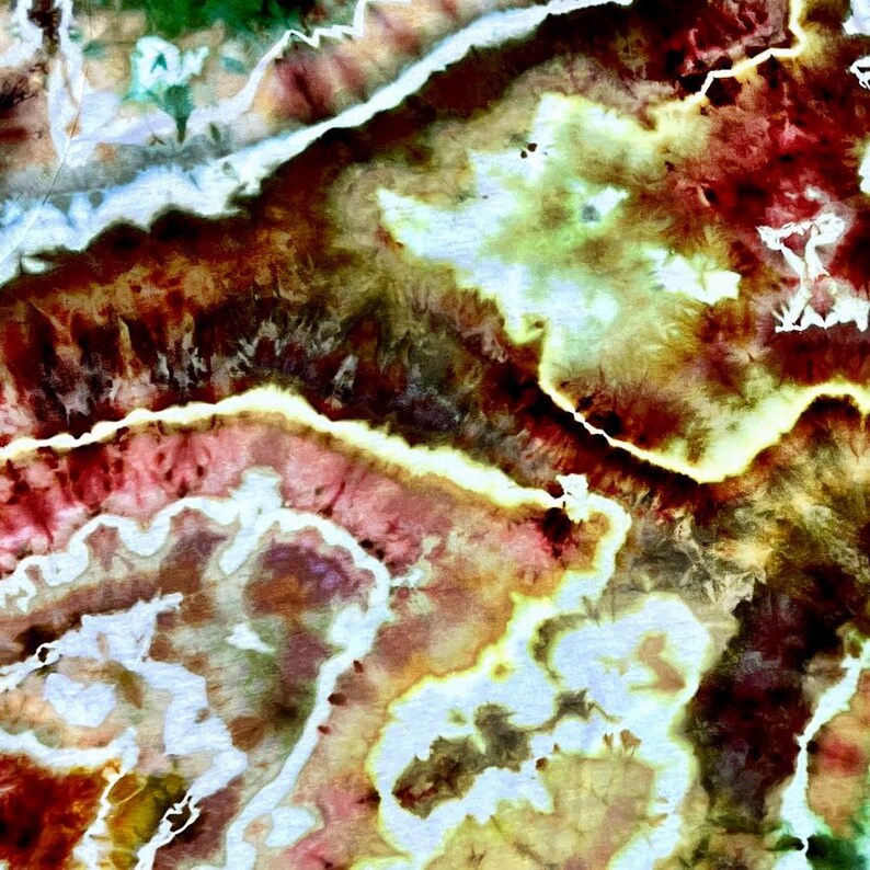 May include: Abstract tie-dye pattern with a blend of colors. The design features a mix of red, brown, yellow, and white hues, creating a textured, organic appearance. The artwork has a watercolor-like effect, with soft edges and blended transitions.