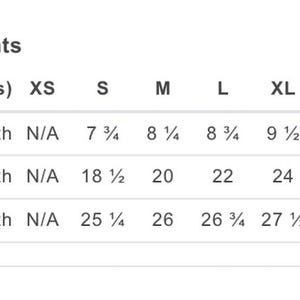 Puede incluir: Un gr&aacute;fico blanco muestra las medidas de la prenda en pulgadas. El gr&aacute;fico incluye la longitud de la manga, el ancho del cuerpo y el largo del cuerpo para las tallas XS a 3XL. Las longitudes de las mangas var&iacute;an de 19.69 a 27.31 cm. Los anchos del cuerpo var&iacute;an de 46.99 a 71.12 cm.