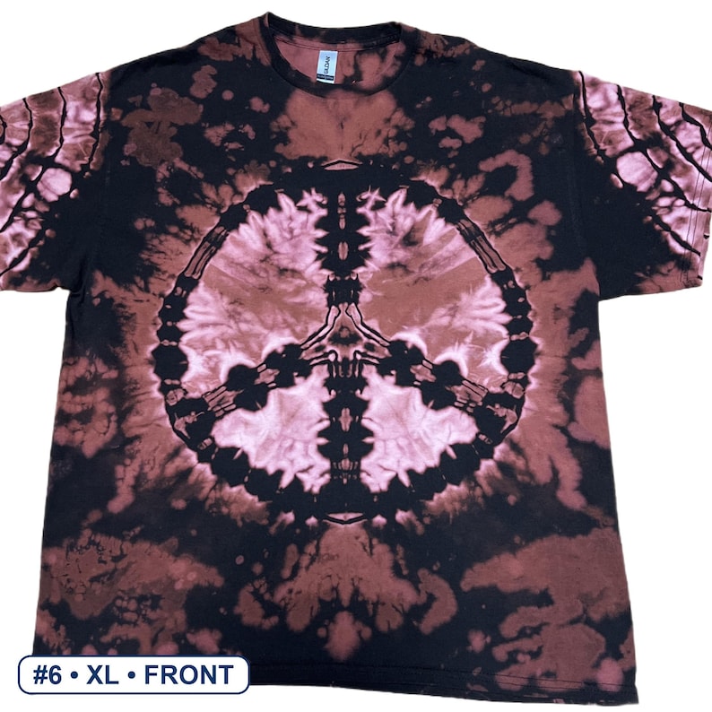 Peut inclure: Un t-shirt &agrave; manches courtes avec un motif tie-dye noir et rose clair et un grand signe de paix centr&eacute; sur la poitrine. Le t-shirt poss&egrave;de une encolure ronde et une petite &eacute;tiquette blanche au col int&eacute;rieur. Le texte indique #6 &bull; XL &bull; FRONT.