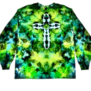 May include: A long-sleeve shirt featuring a tie-dye pattern in shades of lime green, forest green, and dark teal. The center of the shirt displays a prominent white cross shape created through the tie-dye process, set against the vibrant colors.
