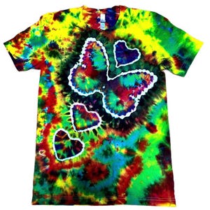 May include: A tie-dye t-shirt with a butterfly and heart design. The shirt features a vibrant mix of colors, including yellow, green, red, and blue. The butterfly and hearts are outlined in white.