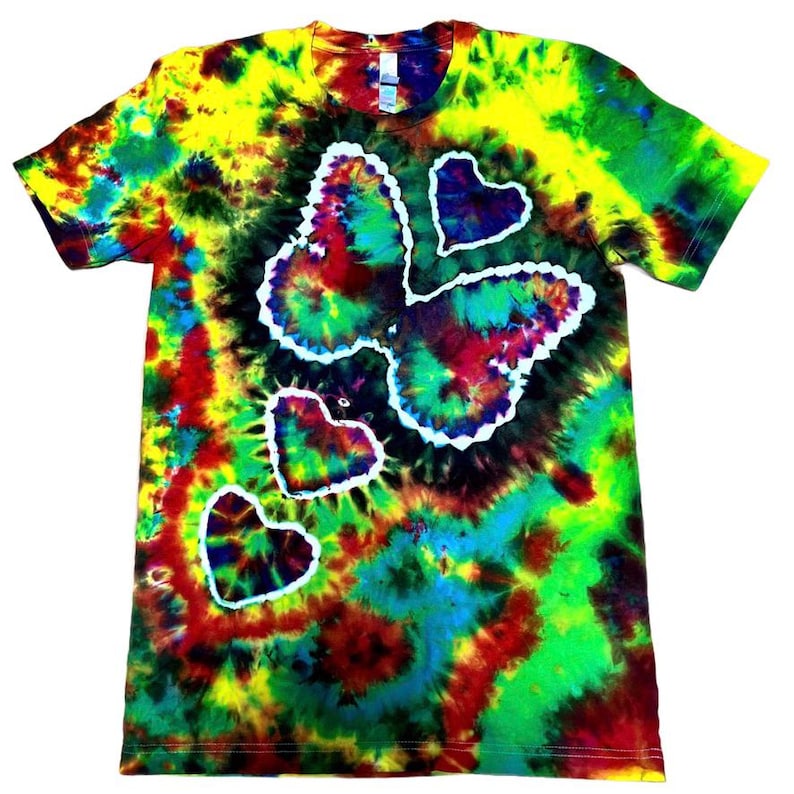May include: A tie-dye t-shirt with a butterfly and heart design. The shirt features a vibrant mix of colors, including yellow, green, red, and blue. The butterfly and hearts are outlined in white.
