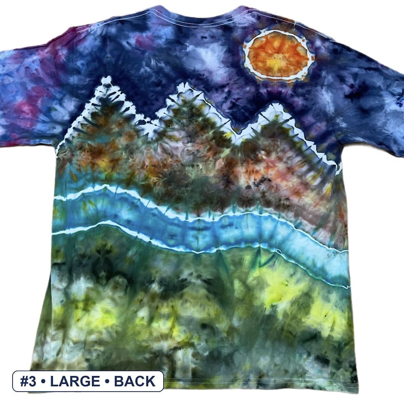 May include: A short-sleeve t-shirt featuring a tie-dye landscape design with a dark blue and purple night sky, a bright orange sun, jagged mountain peaks, a flowing blue river, and a green grassy foreground. The text #3 &bull; LARGE &bull; BACK is visible.