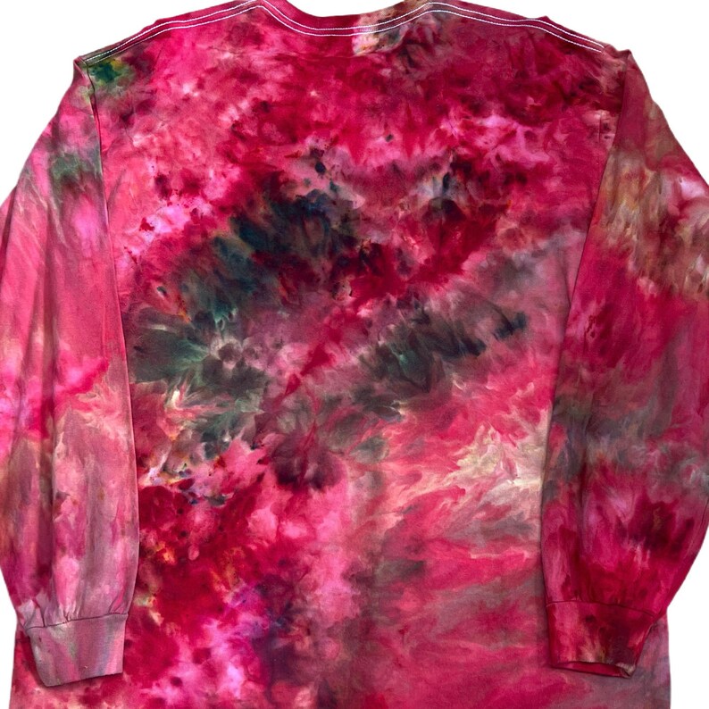 Może przedstawiać: Koszulka z długim rękawem z żywym wzorem tie-dye w odcieniach głębokiego magenty, jasnego r&oacute;żu i ciemnej szarości antracytowej. Tkanina wykazuje wirujący, marmurkowy efekt z mieszanymi kolorami na całym przodzie i rękawach.