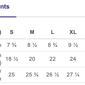 May include: A size chart titled Measurements in inches displaying sleeve length, chest width laid flat, and full body length for sizes S, M, L, XL, 2XL, and 3XL. The table provides specific numerical values in inches for each size category.