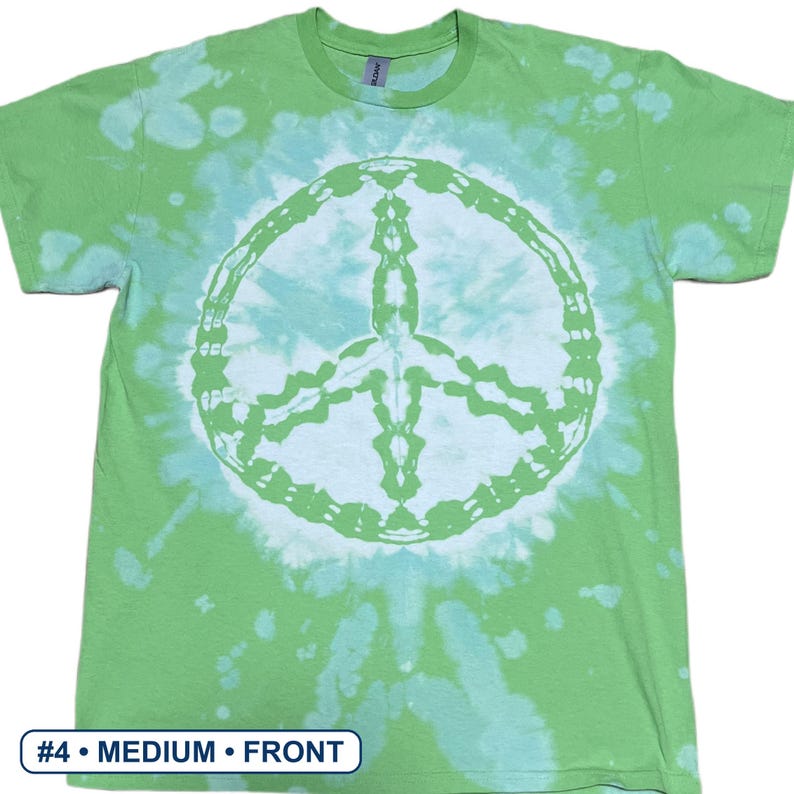 Peut inclure: Un t-shirt &agrave; manches courtes et col rond avec un motif tie-dye dans des tons vert citron et blanc. Le centre du t-shirt pr&eacute;sente un grand signe de paix circulaire blanc. Le texte #4 &bull; MEDIUM &bull; FRONT est visible en bas &agrave; gauche.