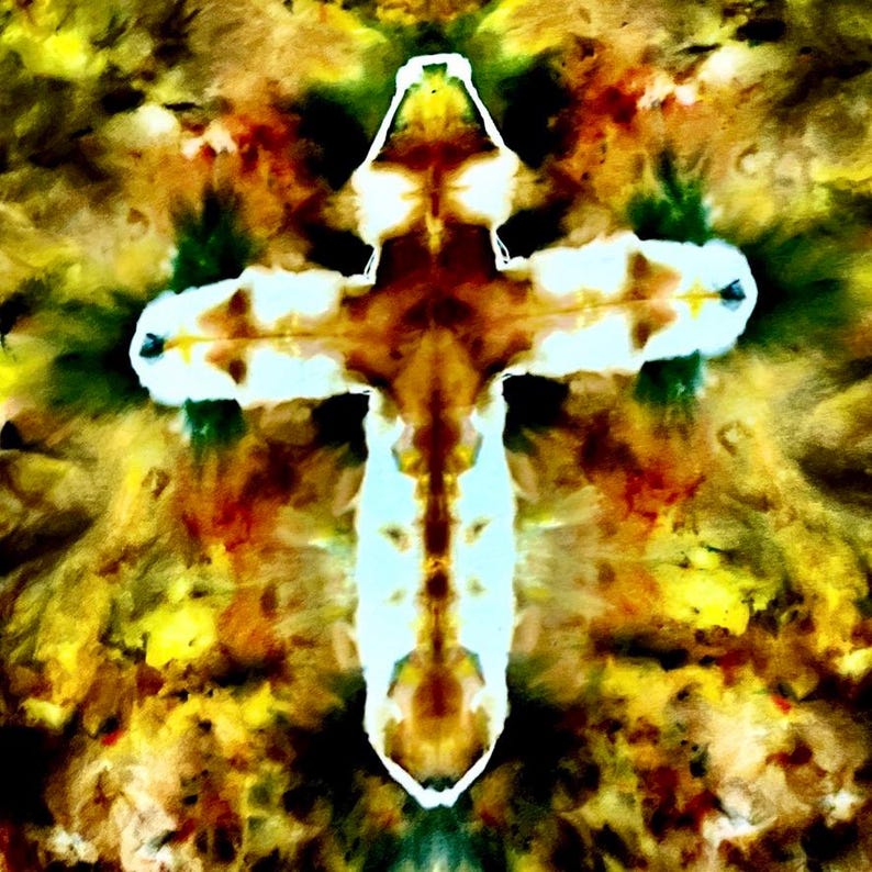 Puede incluir: Un dise&ntilde;o en forma de cruz con un patr&oacute;n tie-dye en tonos vibrantes de amarillo, marr&oacute;n, verde oscuro y blanco brillante. La forma central de la cruz est&aacute; resaltada por un contorno blanco marcado que contrasta con los colores mezclados.
