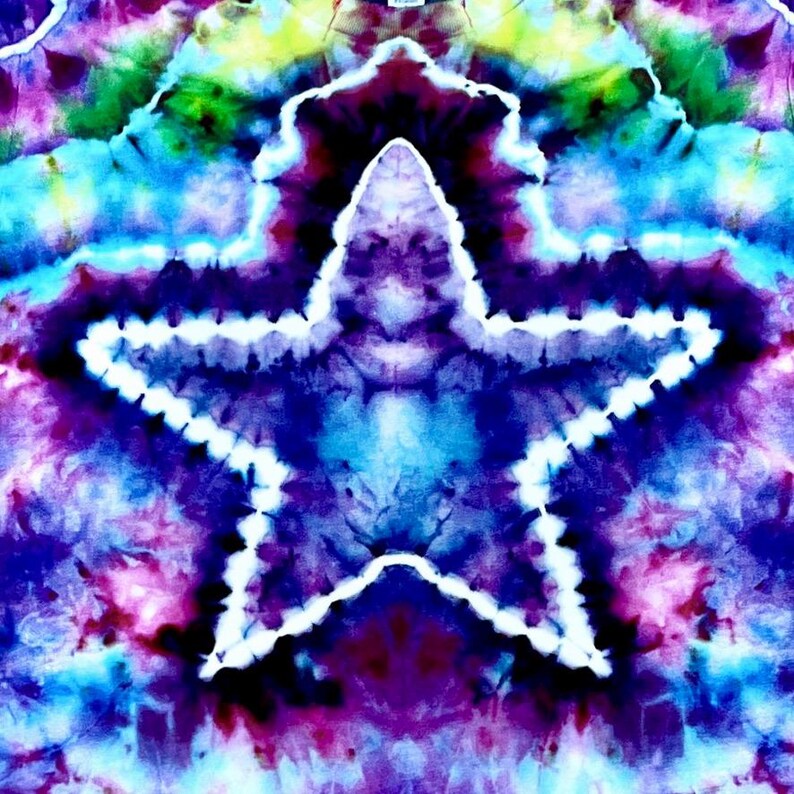 May include: A vibrant tie-dye design featuring a large white outlined star against a backdrop of swirling blues, purples, greens, and yellows. The fabric has a psychedelic, artistic appearance, with a blend of colors creating a unique pattern. The overall effect is visually striking.