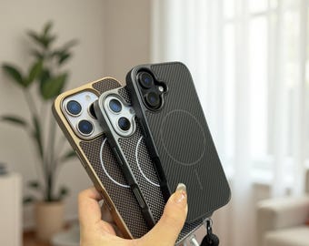 May include: Three phone cases in gold, silver, and black are held in a hand. The cases have a textured design and a circular feature on the back. The black case has a lanyard attached. The cases are designed for a smartphone.