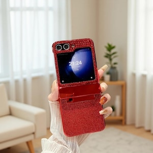 May include: Red glitter flip phone case with a rhinestone-studded frame. The phone screen displays the time 21:24. The case is open, revealing the phone's screen and a card slot.