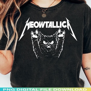 Peut inclure: T-shirt noir avec un motif blanc d'un chat en colère avec les mots "MEOWTALLICA". Le chat a une expression fâchée et des pattes levées. Le t-shirt est de couleur foncée.