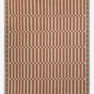 May include: A rectangular rug featuring a repeating pattern of vertical stripes in terracotta and beige. The stripes are interspersed with sections of a checkerboard pattern. A light blue square border frames the rug.