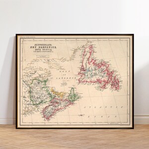 May include: Framed vintage map of Newfoundland, New Brunswick, and Nova Scotia. The map features detailed coastlines and internal borders, with areas colored in red, green, yellow, and blue. The title text is in black, and the map is set against a cream background.