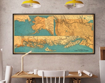 May include: A vintage map of Alaska with a blue and yellow color scheme. The map shows the routes of the Alaska Excursion Steamers. The map is framed and hanging on a wall in a home office.