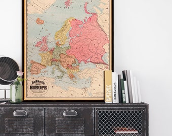 May include: A vintage map of Europe in a black frame hanging above a metal cabinet with four drawers and a wire mesh door. The map is titled "Rand McNally & Co.'s New 11 x 14 Globe Series Europe".