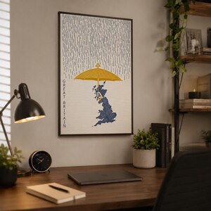 May include: A rectangular wall art print featuring a stylized map of Great Britain in blue, held by a hand under a large yellow umbrella. Vertical rain lines fill the top section, and the text GREAT BRITAIN is printed vertically on the left side.