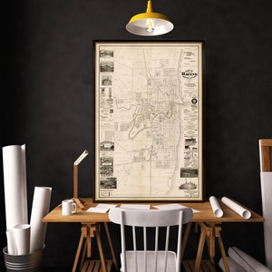 May include: A vintage black and white map of Racine, Wisconsin, framed in a black frame. The map is printed on aged paper and shows the city's streets, parks, and landmarks. The title of the map is "The Racine National Bank Map of Racine".
