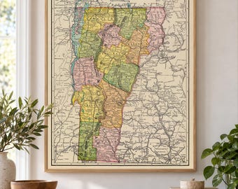 Könnte beinhalten: Eine Landkarte von Vermont im Vintage-Stil mit pastellfarbenen Bezirken, schwarzer Beschriftung und detaillierten topografischen Linien. Die Karte ist in einem hellen Holzrahmen gefasst und zeigt die Geografie des Bundesstaates mit klaren Grenzen.