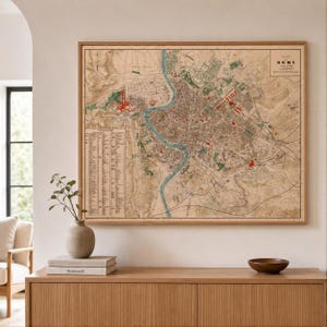 May include: A framed vintage map titled Plan de Rome, featuring a detailed topographical layout of the city with the Tiber River in blue, red landmarks, and green park areas. The map includes a legend on the left and text in the top right corner.