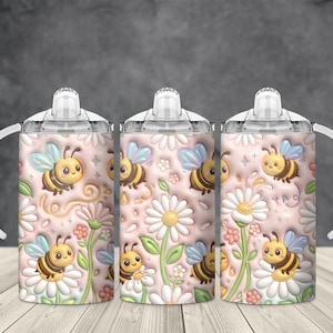 Peut inclure: Trois gobelets à bec avec poignées et couvercles blancs. Les gobelets présentent un motif répété d'abeilles de dessins animés, de marguerites et d'autres éléments floraux sur un fond rose. Les abeilles ont des rayures jaunes et noires et des ailes bleues.