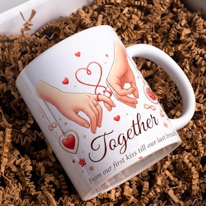 May include: White ceramic mug with a handle, featuring a romantic illustration of two hands with a red heart-shaped string. The word "Together" is written in a cursive font, with the phrase "From our first kiss till our last breath."