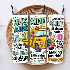 May include: A white tumbler with a black straw features a yellow school bus illustration and the words "BUS AIDE." Additional text includes "Be quiet inside voice" and "Making bus rides magical." The tumbler is decorated with stars and hearts.