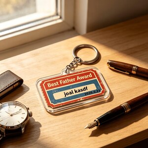 May include: A clear acrylic keychain with a silver metal ring. The keychain has a rectangular design with a red and blue graphic that reads "Best Father Award" and includes the name "joal kasdf" and the date "2026.6.21".