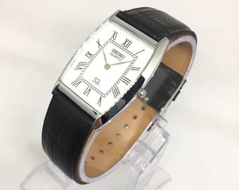 Reloj de pulsera Seiko SQ Quartz Barrel Tank vintage: esfera romana blanca, correa de cuero negra