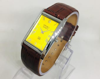 Reloj de pulsera Seiko SQ Quartz Tank vintage: esfera romana amarilla, correa de cuero marrón