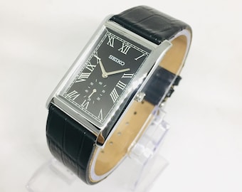 Reloj de pulsera vintage Seiko Tank Quartz con segundero lateral: esfera romana negra, correa de cuero negra