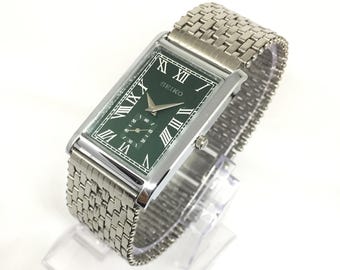 Reloj de pulsera vintage Seiko Tank Quartz con segundero lateral, esfera romana verde y cadena de acero inoxidable.