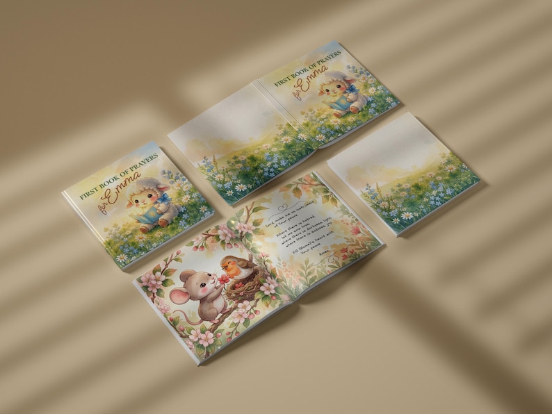 May include: A square children's book titled First Book of Prayers for Emma, featuring illustrations of a lamb, a mouse, and a robin in a field of flowers. The book is shown in multiple views, including the cover and an open page with text.
