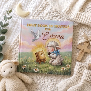 May include: A hardcover book titled First Book of Prayers for Emma featuring a white dove, a small lamb with a blue bow, and a Bible on a stand in a field of daisies. The illustration uses soft pastel colors against a light sky background.