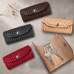 Puede incluir: Estuches para llaves de cuero en varios colores, incluyendo marrón, negro, rojo y beige. Cada estuche presenta un diseño tejido o texturizado y un cierre de botón a presión plateado. Uno de los estuches está abierto, mostrando llaves.