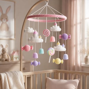Colgante de cuna de ganchillo con temática de reino de dulces, móvil de castillo de nubes de azúcar caprichoso, decoración infantil con dulces en tonos pastel.