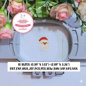 May include: A machine embroidery design of a Santa Claus face featuring a red hat with white trim, a red nose, and a white beard, centered in a gray embroidery hoop. Text includes Machine Embroidery Designs, Instant Download, and 10 sizes from 0.89" x 1.02" to 2.89" x 3.26".