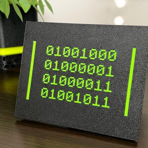Angled view of four green binary rows on a textured black plaque.