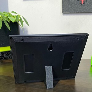 Rear of the plaque upright on its removable black desk stand.
