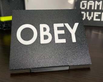 Placa de escritorio y pared OBEY – Letrero de ciencia ficción inspirado en They Live
