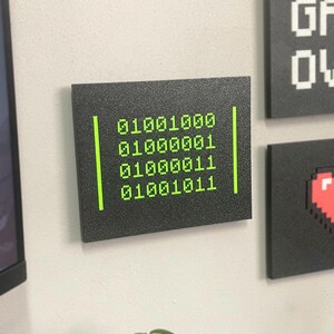 Close wall view of the HACK Binary plaque with other designs sold separately.