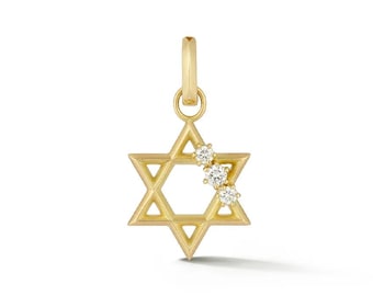 May include: A gold Star of David pendant featuring a smooth, polished finish. The six-pointed star design includes three small, clear, round-cut stones set along one of the upper diagonal bars, and it includes a small circular bail at the top.